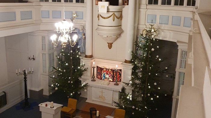 Großer Raum mit zwei Weihnachtsbäumen und grosser Uhr