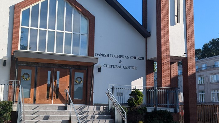Church with tall bell tower and cross, clear blue sky
