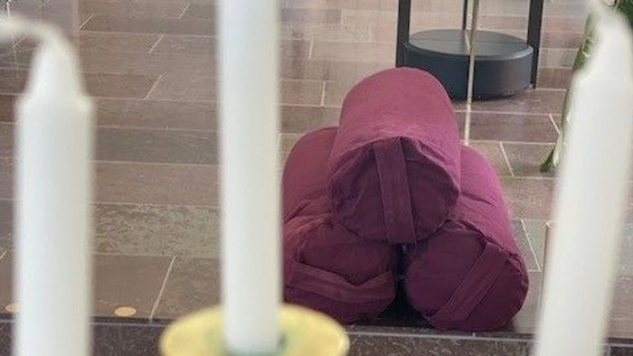 En person sidder på gulvet i en rød pyjamas.