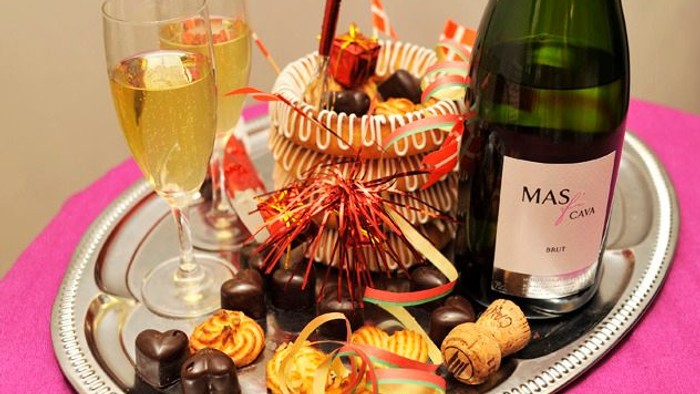 En trays med champagne, glas, chokolade og pynt