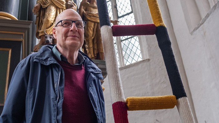 Frau steht vor farbenfroher Treppe in Kirche