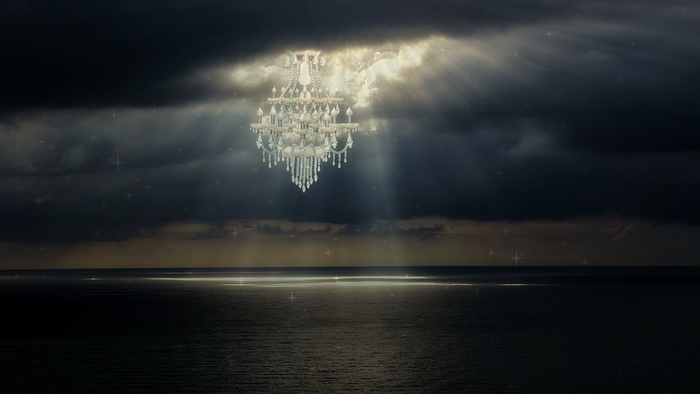 En stor kandalaber hænger i mørkt skyoverskyd over havet