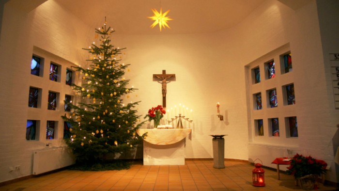 Weihnachtsdekoration in Kirche mit Christbaum und Kreuz