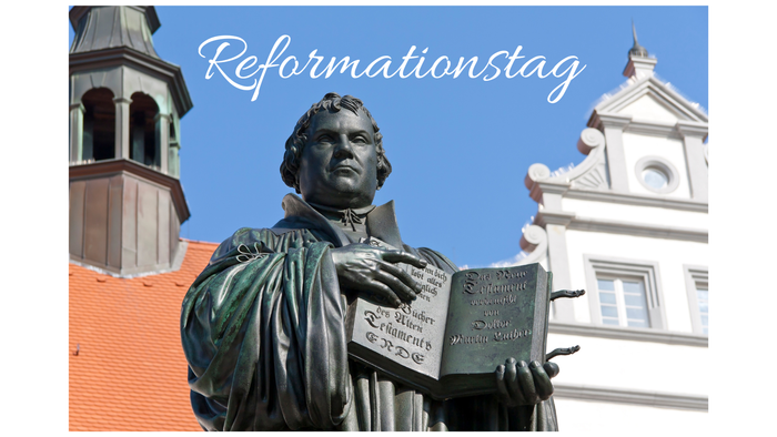 Statue mit Buch, darüber steht „Reformationstag“