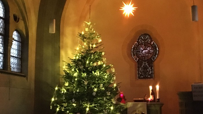 hier sieht man denn geschmückten und hell strahlenden Tannenbaum in der Johanneskirche, oben rechts leuchtet ein Herrnhuter Stern.