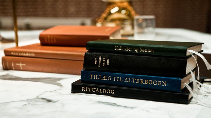 En stabel af bøger på marmorhylde, bl.a. 