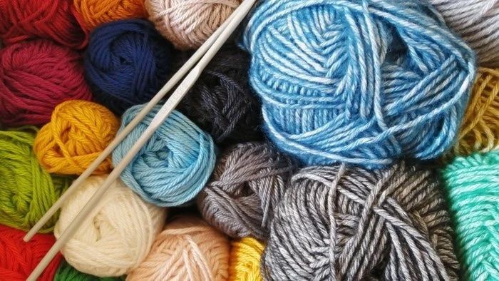 Bunte Wollknäuel mit Stricknadeln