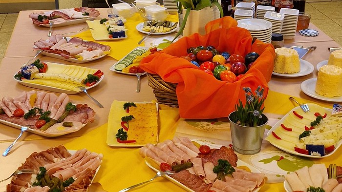 Ein Tisch mit verschiedenen Speisen und Getränken, Blumen und Geschirr