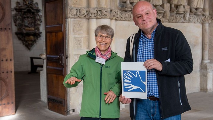 Ein freundliches Paar vor dem Eingang zum Paulsdum. Er hält das Bild für Gebärdensprache.