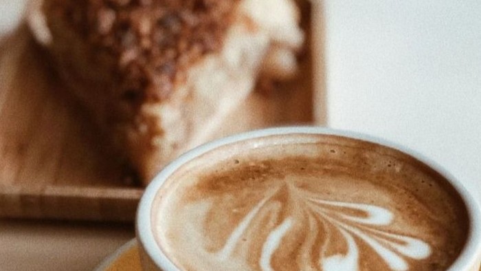 Ein Cappuccino und ein Stück Kuchen auf einem Tisch