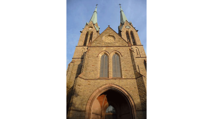 Gotische Kirche mit Zwillingstürmen und bogigem Eingang.