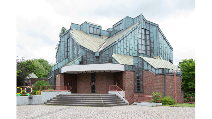 Moderner Bau mit Glas- und Ziegelfassade, der eine große Freitreppe zum Eingang aufweist.