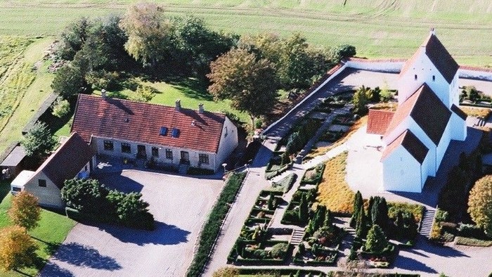 En stor landbrugsejendom med store haver og parkeringsekspladser.