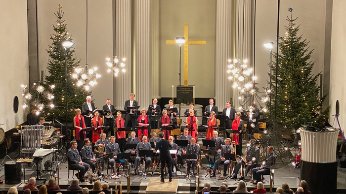 Kirkekor optræder med julekoncert med pyntede træer og publikum.