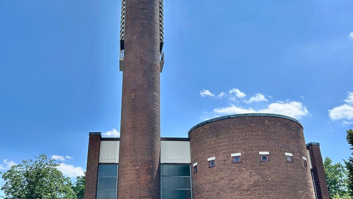 Gebäude mit hohem Schornstein und modernen Fenstern