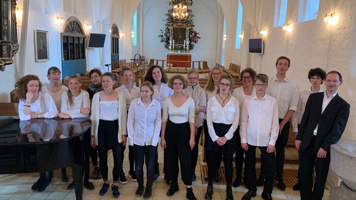 Ein Chor steht in einer Kirche und posiert für ein Gruppenfoto.