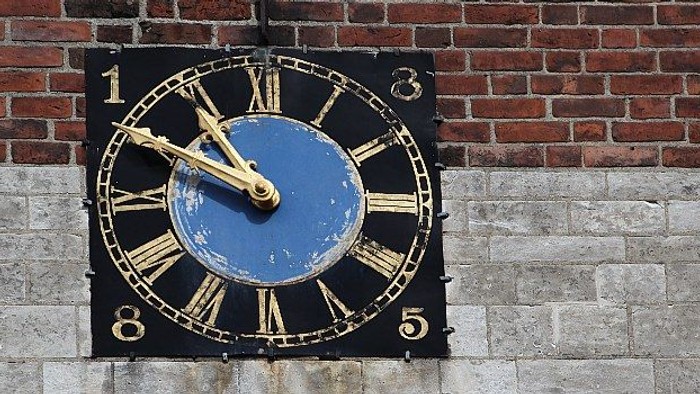 En stor murklokke med blå og gul farve monteret på en mur.