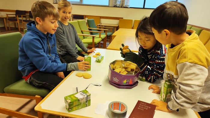 Børn spiser og ser på billeder i bog
