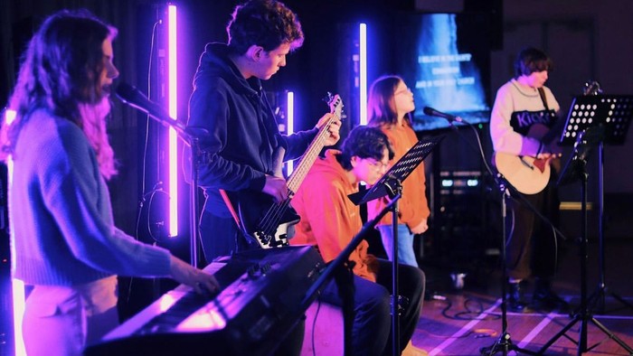 A band performs on stage with various instruments.