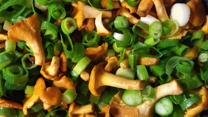 Das Bild zeigt eine Pfanne mit Pilzen und Schnittlauch.