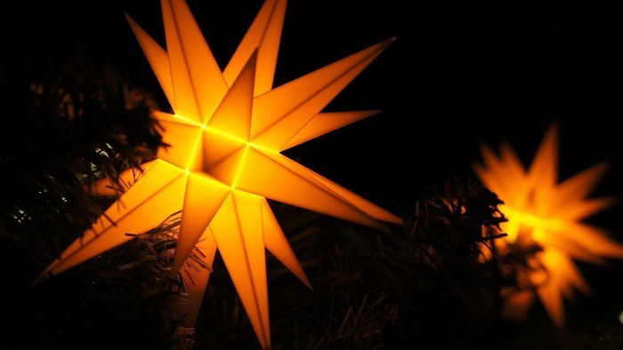 Zwei leuchtende orangefarbene Sterne in der Dunkelheit