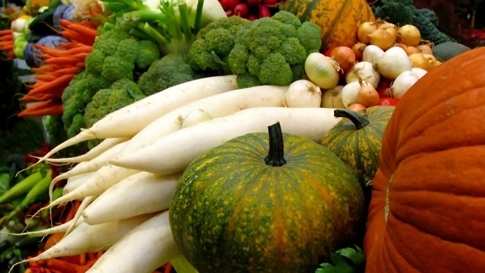 En markedsbude med en mangfoldighed af ferske grøntsager og pumpker