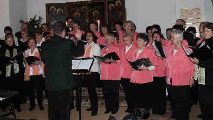 Ein Chor proben mit Musikern und Dirigenten in einem Raum