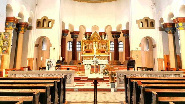 Innenraum einer Kirche mit Kreuz und Kirchenbänken