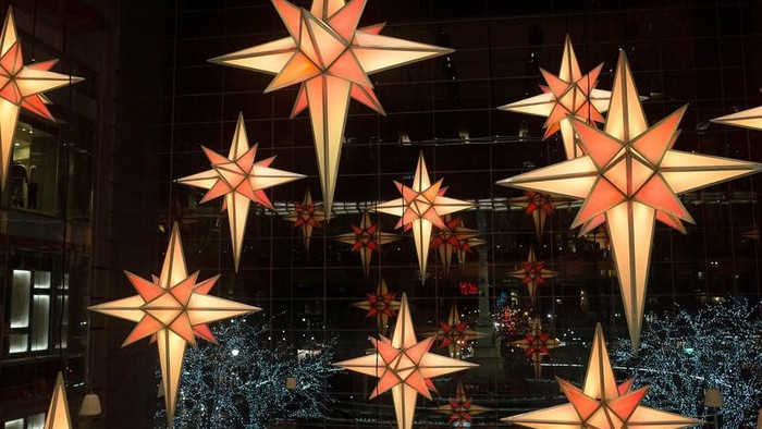 "Sternendekorationen in einem dunklen Raum aufhängen"