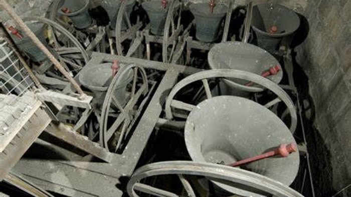 Stacked metal chairs in a dimly lit room.