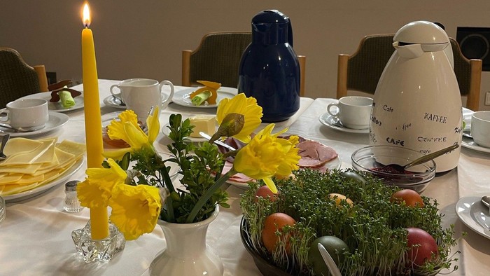 Elegant gedeckter Tisch mit frischen Blumen, Kerzen und festlichen Speisenarrangements in einem gemütlichen Essbereich.