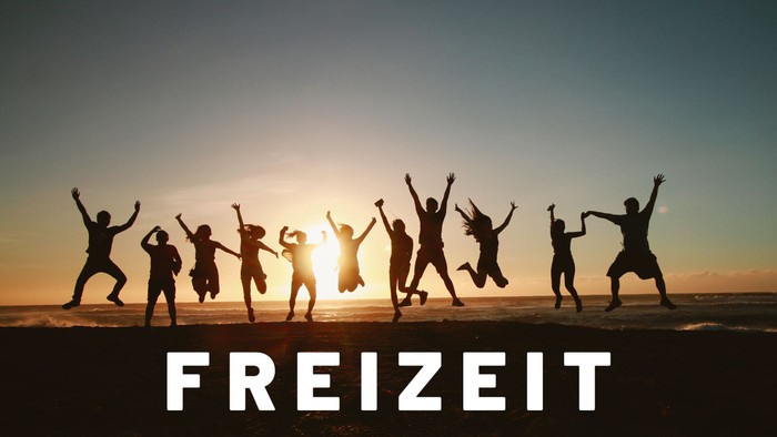 Eine Gruppe von Menschen feiert freudig am Strand bei Sonnenuntergang