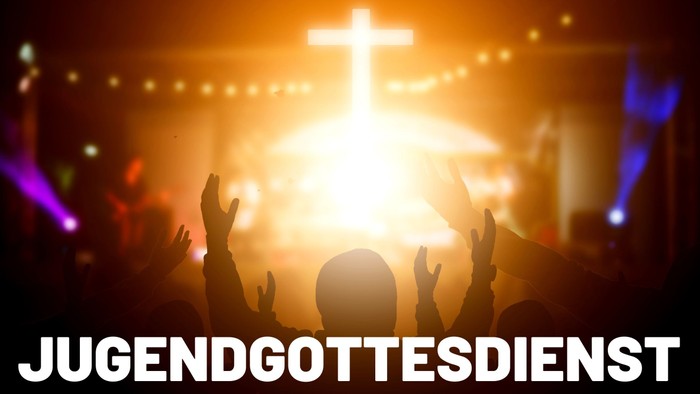 Eine Gruppe von Menschen betet vor einem großen Kreuz bei einer Jugendgottesdienstveranstaltung