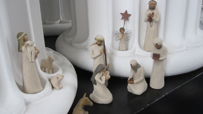 En lille julekreds med flere figurer og et stjernetop.