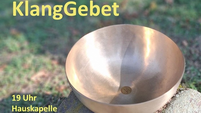 Eine Klangschale auf einem Stein in einer Wiese 