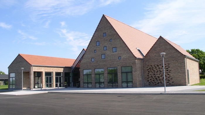 Det moderne bygning med brune tag og store vinduer.