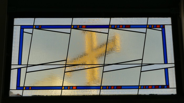 Ein farbiges Glasfenster mit geometrischen Mustern und Lichtstrahlen