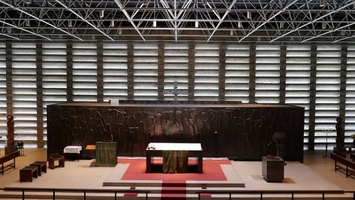 Modernes Kircheninnere mit Altar und Holzbänken