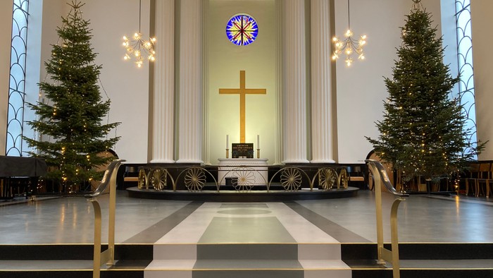 Indre del af kirke med juletømmer og alter.