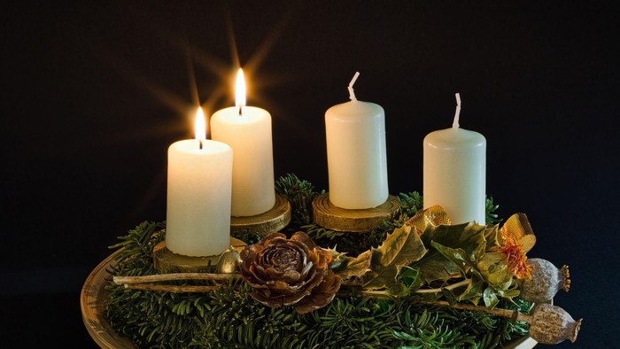 Zwei brennende weiße Kerzen am Adventskranz