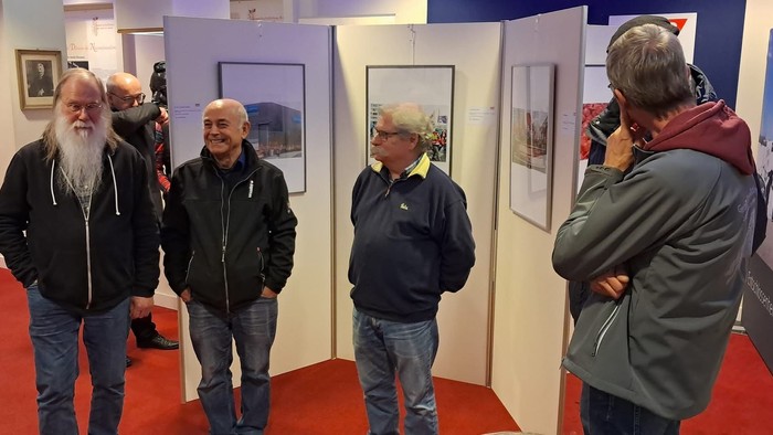 Eine Gruppe älterer Männer besichtigt eine Kunstausstellung.