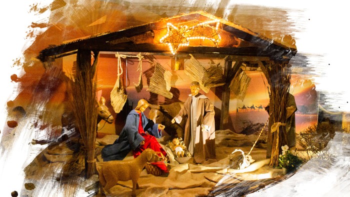 Ein rustikales Weihnachtskrippenbild mit Maria, Josef und dem neugeborenen Jesus in einer Stallung.