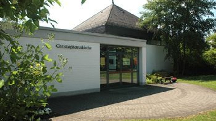 Kleines weißes Gebäude mit dem Schild *„Christophophotografie“* und großen Fenstern.