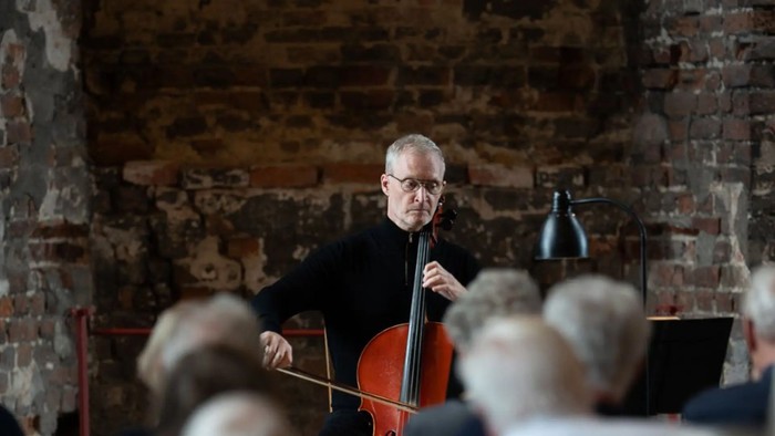 Mand spiller cello foran publikum