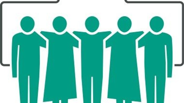 Fünf Personen stehen in einer Gruppe unter einem Kreuz