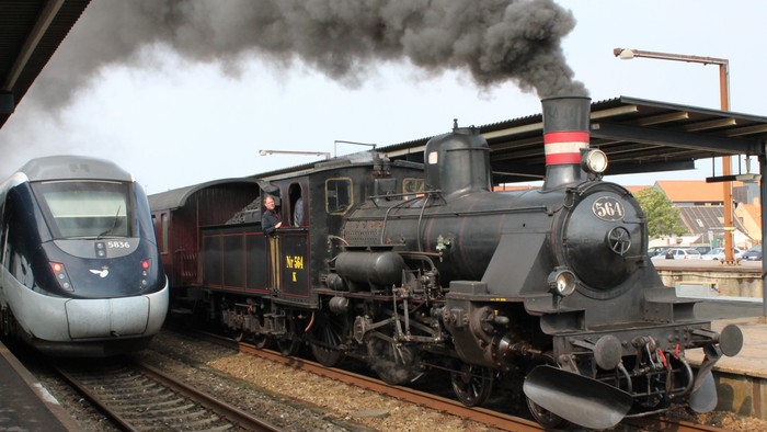 Moderne lyntog og veterantog side om side på jernbaneskinner