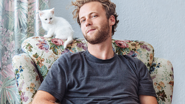 Mann mit Katze auf dem Sessel