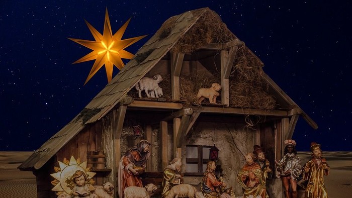 En julekreds med Jesusbarnet, Maria, Josef og dyr i en hytte under stjernen.