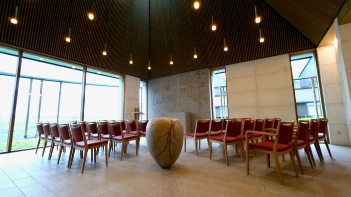 En moderne konferenceværelse med røde stoler og store vinduer.