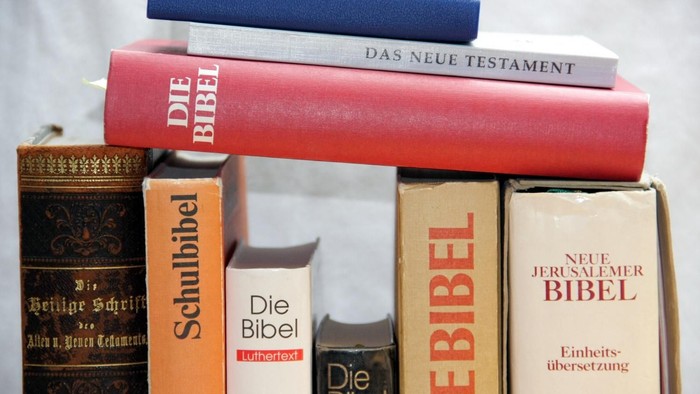 Mehrere Bibeln in verschiedenen Übersetzungen und Sprachen gestapelt